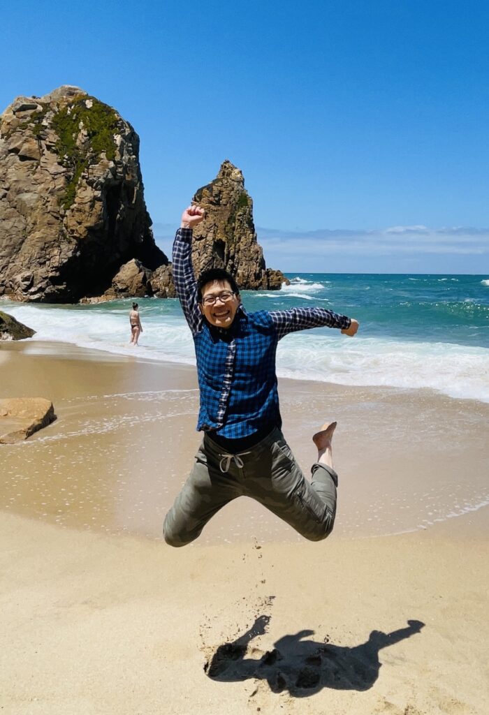 wen jumping on a beach. taking a leap